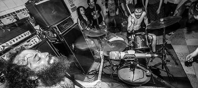 black and whit picture of the band playing in the middle of the crowd